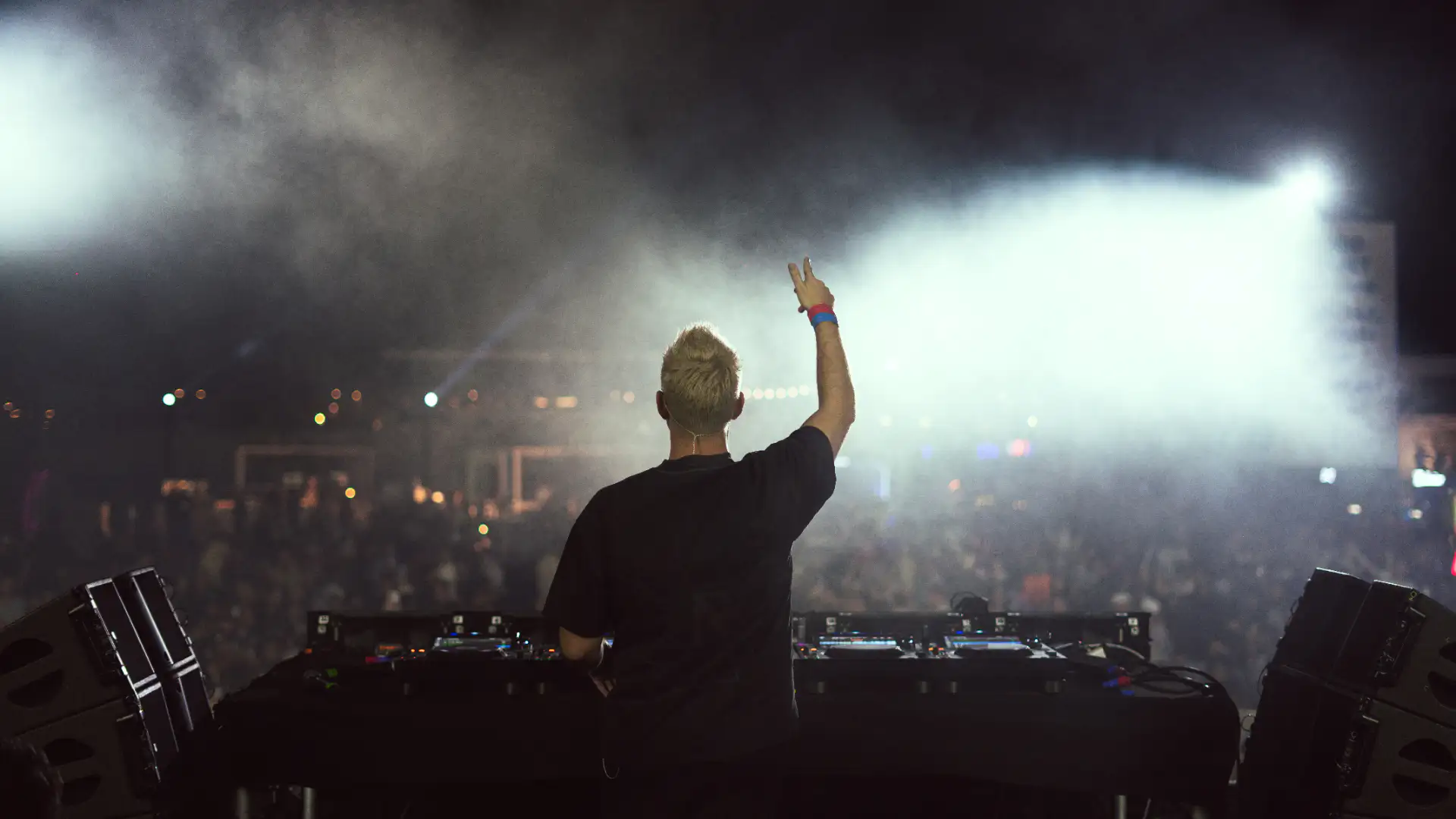 Scott Forshaw on stage in a Metallica tee with arm raised to a festival crowd